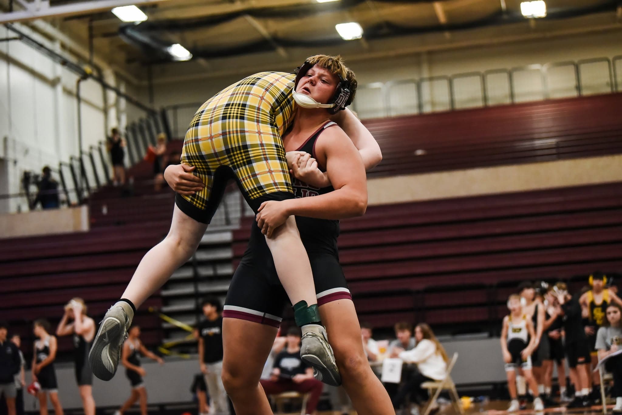 Dowling Catholic wrestler lifting an opponent during a match